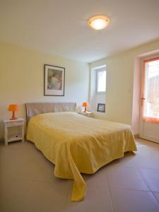a bedroom with a bed with a yellow blanket on it at Le Jas de Verdolier in Sault-de-Vaucluse