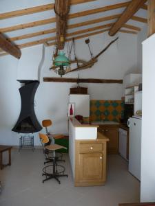 a kitchen with wooden ceilings and a green chandelier at Le Jas de Verdolier in Sault-de-Vaucluse