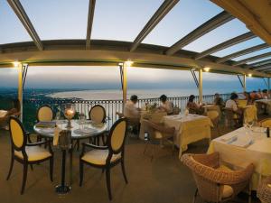 restauracja ze stołami i krzesłami oraz widokiem na ocean w obiekcie Hotel Posillipo w mieście Gabicce Mare
