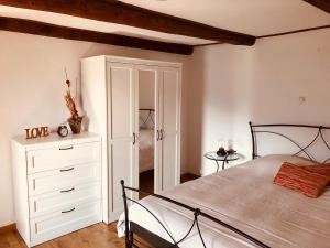 um quarto com uma cama e uma cómoda branca em Casa Ruscada em Borgnone