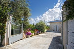 un cancello per una casa con fiori e piante di B&B Il Brigante ad Alberobello