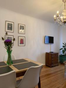 a dining room with a table and a tv at Ferienwohnung West in Stuttgart