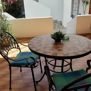 un tavolo da giardino e sedie con una pianta in vaso sopra di Villa Dora Studios a Mpatsi (Batsi)