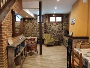 een woonkamer met een bakstenen muur bij La Calleja in Villarejo del Valle