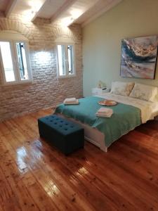 una camera da letto con un letto grande e un muro di mattoni di C & A House a Città di Corfù