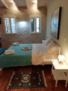 una camera con un grande letto e due finestre di C & A House a Città di Corfù