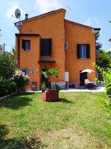 una casa arancione con un cortile davanti di Casa L'Osservanza a Cesena
