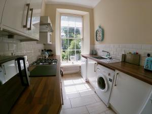 a kitchen with a washing machine and a window at Escape To Edinburgh @ Broughton Place in Edinburgh