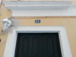una porta con il numero sul lato di un edificio di C & A House a Città di Corfù