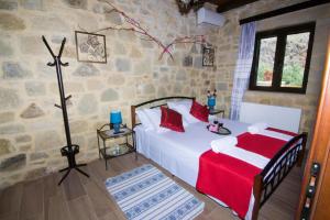 a bedroom with a bed in a stone walled room at Mansion Rokka with BBQ and Fireplace in Kissamos