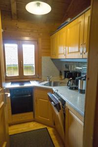 a kitchen with wooden cabinets and a sink and a stove at Ferienhaus Bayern in Stamsried +15 photos