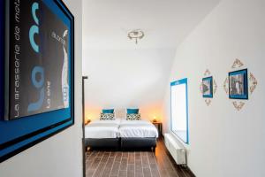1 dormitorio con cama y pantalla grande en Zythogite Appartement 6 personnes avec jardin, bbq en Tintigny