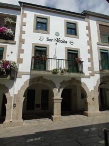 a building with balconies and flowers on it at Casa San Nicolás in Portomarin