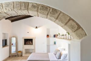 um quarto com uma cama com um arco de pedra em Masseria Vittoria em Acaya