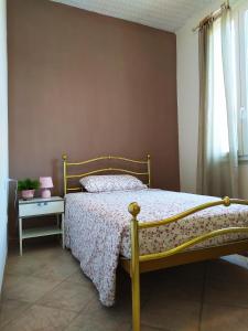 una camera con letto con struttura gialla di Casa L'Osservanza a Cesena