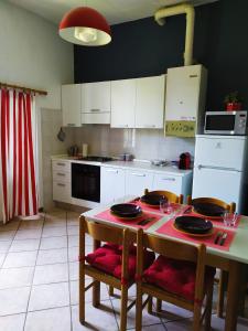 una cucina con tavolo con due sedie e tavolo e una cucina con di Casa L'Osservanza a Cesena