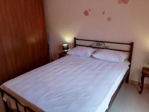 a bedroom with a bed with white sheets and two pillows at Aspa's Apartment in Kavala