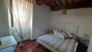 a bedroom with a white bed and a window at il nido dell'arancio in Carrara +4 photos