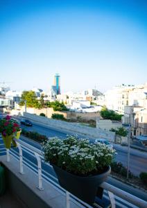 a balcony with two potted plants and a highway at Couple's Getaway in Is-Swieqi