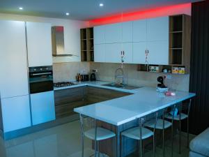 a kitchen with white cabinets and a blue counter top at Couple's Getaway in Is-Swieqi