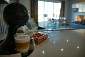 a glass of beer and a bowl of fruit on a table at Couple's Getaway in Is-Swieqi