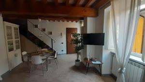 a living room with a table and chairs and a staircase at il nido dell'arancio in Carrara