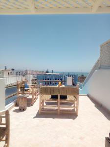 een patio met tafels en stoelen op een dak bij Riad Etoile De Mogador in Essaouira