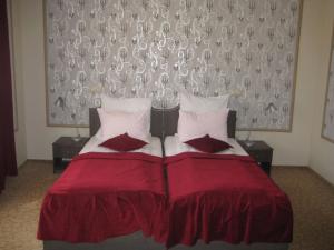a bedroom with a red bed with two pillows at Pension Casa Frieda in Sibiu