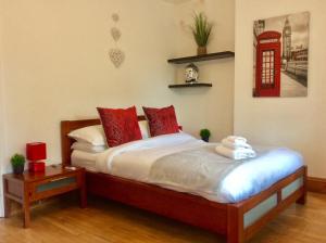 a bedroom with a bed with red pillows and a phone booth at Station House in Didcot