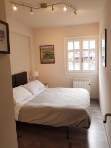 a bedroom with a large bed with a window at Apartamento moderno Vielha centro in Vielha