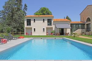 a swimming pool in front of a house at L Esprit du Clain chambres d hôtes au calme proches du Futuroscope Golf et Lac de St Cyr in Naintré