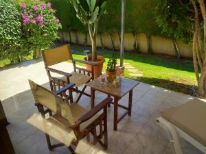 eine Terrasse mit einem Tisch, 2 Stühlen und einem Baum in der Unterkunft Residence L' Aubrais in Limassol