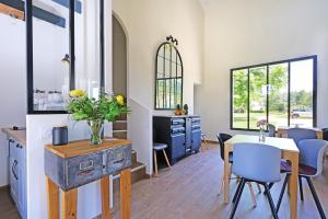 a kitchen and dining room with a table and chairs at L Esprit du Clain chambres d hôtes BandB de standing proches du Futuroscope Golf et Lac de St Cyr in Naintré