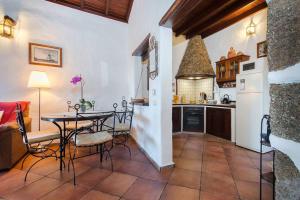 una cucina con tavolo e sedie in una cucina di El Caserío de Güime Villa con Piscina Climatizada a San Bartolomé