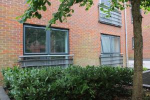 a person looking out the window of a brick building at City Apartment in Winchester