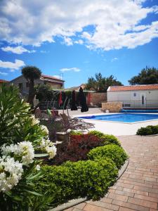a garden with flowers and a swimming pool at Villa Anja 2nd floor in Peroj