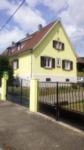 a yellow house with a black fence at Gîte Yves in Wihr-au-Val