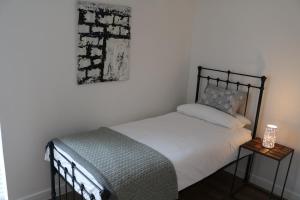 溫徹斯特的住宿－City Apartment，卧室配有一张床,墙上挂着一幅画