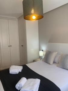 una camera da letto con un grande letto con due asciugamani di AZ El Balcón de Boggiero II a Saragozza