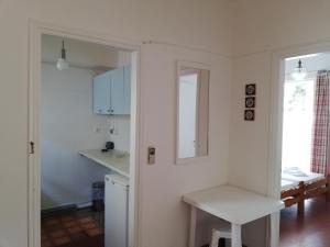 Zontanos Studios & Apartments في بوروس: مطبخ أبيض مع طاولة ومرآة