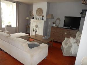 a living room with two white couches and a tv at Gîte des petites Poules rousses 9 personnes Zoo Parc Beauval Saint Aignan et Châteaux de la Loire in Choussy