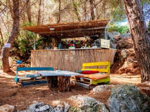 a picnic table and chairs in the woods at THE SEA CAVE CAMPING in Himare