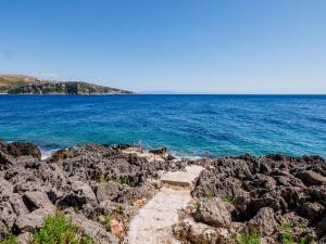 un sentiero sulle rocce vicino all'oceano di THE SEA CAVE CAMPING a Himare