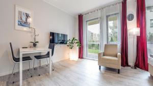 a living room with a desk and a table and chairs at Sopot Residence - Sea Deluxe apartment B in Sopot