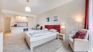 een slaapkamer met een groot wit bed en een stoel bij Sopot Residence - Sea Deluxe apartment A in Sopot
