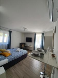 a bedroom with a bed and a table with wine glasses at Apartments Borghetto in Vinkuran