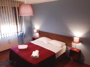 een slaapkamer met een bed met twee handdoeken erop bij Home Sweet Home Affittacamere - Lucca in Lucca