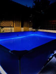 a blue swimming pool in a yard at night at Bihari Vendégház in Felsőtárkány