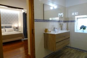 ein Badezimmer mit Waschbecken und Spiegel und einem Bett in der Unterkunft Quinta Vale do Homem in Amares