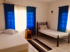 a bedroom with two beds and blue curtains at Kevin's Court in Carnbee Village